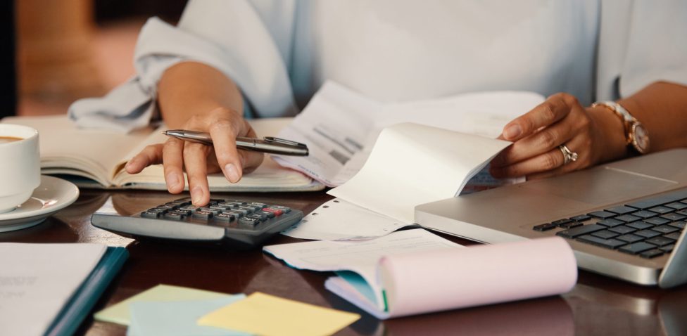 Hands of female entrepreneur working with bills and documents